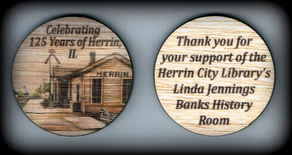 Front of wooden nickels reads Celebrating 125 Years of Herrin, Il. Back of wooden nickel says Thank you for your support of the Herrin City Library;s Linda Jennings Banks History Room. Nickels feature a depot picture of Herrin and are light brown color. 